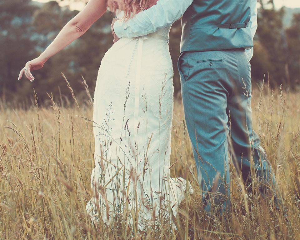 bride and groom in hayfield
